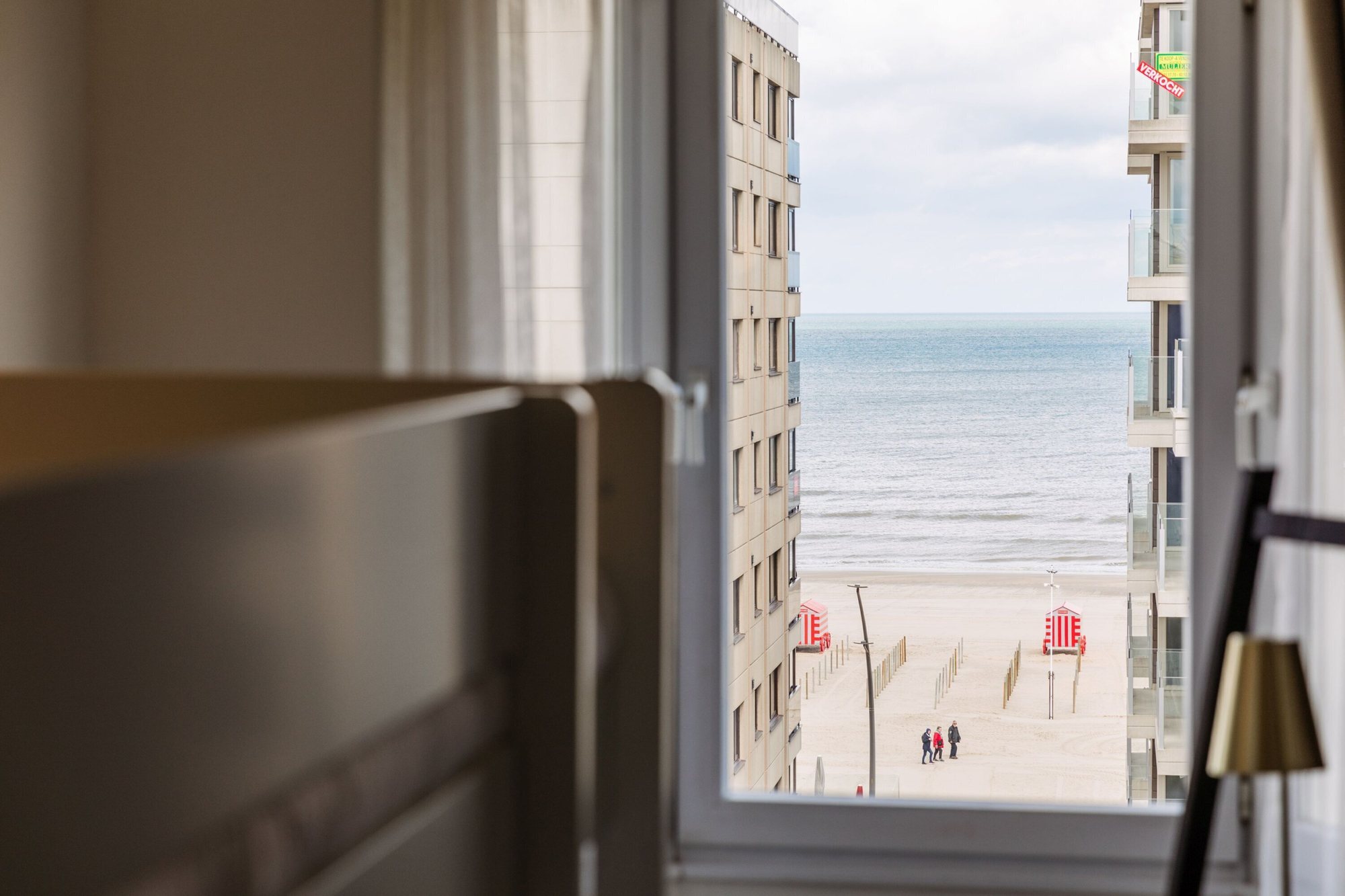 Zicht vanuit een hotelkamer op het strand en de zee in De Panne